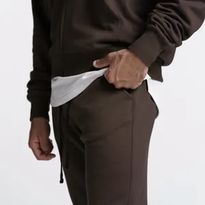 Nahaufnahme der braunen Herren-Jogginghose mit Seitentasche und Kordelzug-Detail.