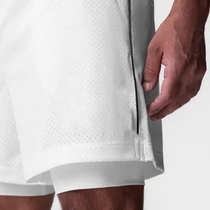 Vista detallada de pantalones cortos deportivos blancos de doble capa con tejido de malla.