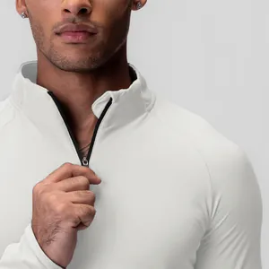 Close-up detail of men's white quarter-zip compression long sleeve fitness sports shirt.