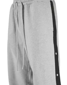 Dettaglio dei pantaloni da basket grigi da uomo con fodera in pile e bottoni laterali