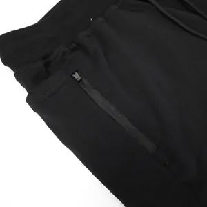 Close-up of black men's athletic shorts featuring a secure zippered side pocket and waist