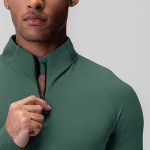 Detailed close-up of men's half-zip compression sports top showing green fabric texture