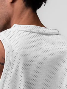 Gros plan sur le tissu en maille respirante et les coutures d'un débardeur de sport blanc pour homme