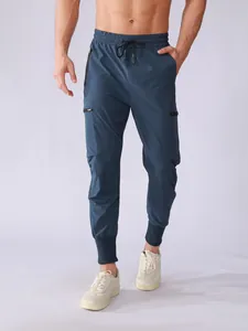 Detailed view of men's quick-dry blue joggers with multiple zipper pockets and tapered cuffs.