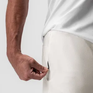 Primer plano detallado del bolsillo con cremallera en pantalones cortos blancos hombre
