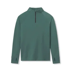 Detail of dark green men's athletic compression shirt with half-zip and thumbholes