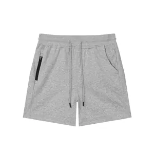 Close-up of grey cotton sports shorts featuring a black zipper pocket and drawstring.