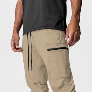 Detailansicht der khakifarbenen Outdoor-Cargohose mit Reißverschlusstasche und Kordelzug.