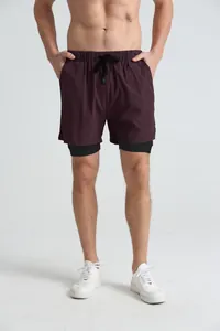 Detail view of men's 2-in-1 burgundy fitness shorts with elastic waist and black liner.