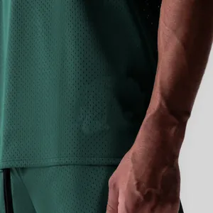 Détail de près du tissu en maille respirante vert foncé sur un débardeur sport