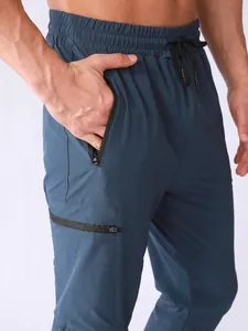 Detail shot of men's quick-dry sports pants showing zipper pockets and woven fabric