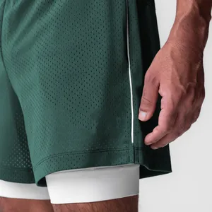 Detalle de los pantalones cortos deportivos de malla verde oscuro con forro interior blanco.