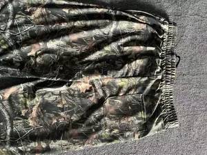 Detailed view of forest camouflage pattern on men's loose jogging pants with pocket