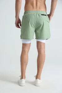 Rear view of men's green 2-in-1 sports shorts with white inner lining for fitness