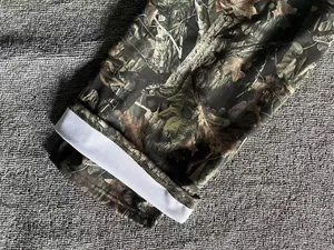Close-up detail of forest camouflage jogger pants for men with white elastic cuff