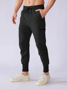 Detail of black quick-dry athletic joggers with cargo pockets and drawstring waist for men