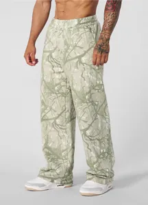 Detailed view of men's loose jogging pants with digital forest branch pattern