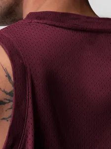 Gros plan sur le tissu en maille bordeaux respirant d'un débardeur de sport pour hommes