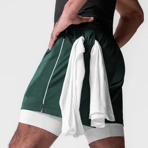 Detalle de los pantalones cortos deportivos verdes de doble capa con lazo para toalla.