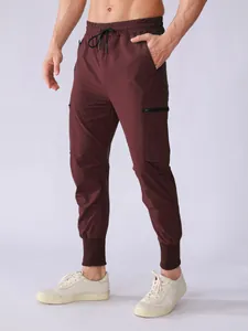 Close-up view of men's quick-dry burgundy cargo pants with tapered ankle and multi-pockets