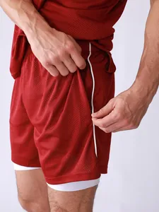 Close-up of men's red mesh sports shorts with zipper pocket and double-layer design
