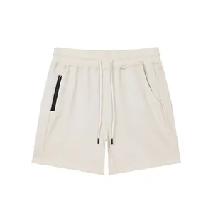 Front view of men's beige athletic shorts with drawstring waist and zipper pocket