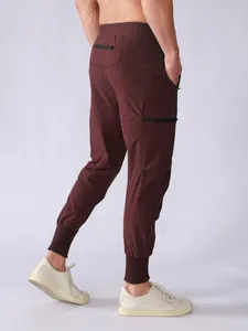 Detail of burgundy men's quick-dry joggers featuring multi-pockets and ribbed cuffs.