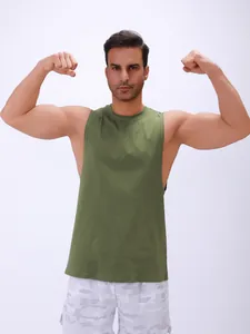 Professioneel mannelijk model toont spieren in een groene mouwloze fitness tanktop