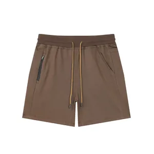 Flat lay view of men's brown cotton athletic shorts with elastic waist and zipper pocket