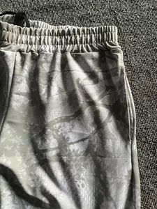 Close-up detail of forest pattern jogging pants with elastic waistband and pocket