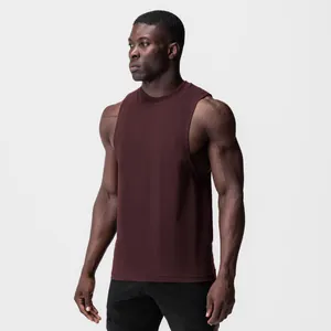 Side view of a muscular man wearing a burgundy gym tank top with wide armholes.