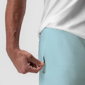 Detalle del bolsillo con cremallera oculta en shorts deportivos azules hombre
