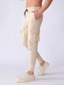 Close-up of beige men's quick-dry cargo joggers with drawstring and side pocket