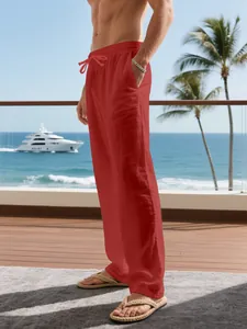 Close-up of red loose linen trousers for men with drawstring waist in a vacation setting