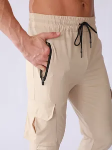 Close-up detail of khaki quick-dry cargo pants for men with a zipper pocket and drawstring