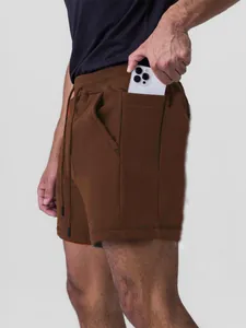 Men's brown cotton sports shorts with functional phone pocket for running and gym.