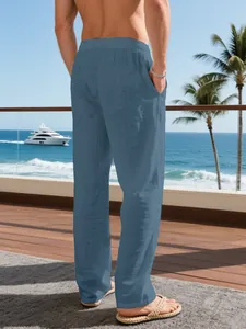 Back view of men's loose blue linen trousers in a seaside vacation resort setting