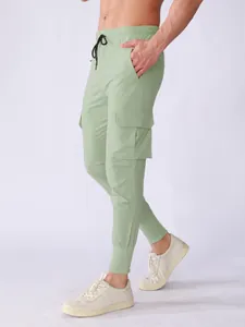 Side view of men's light green quick-dry cargo pants with flap pockets and tapered cuffs