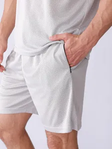 Vue détaillée du short de sport en maille grise pour hommes avec poche zippée latérale.