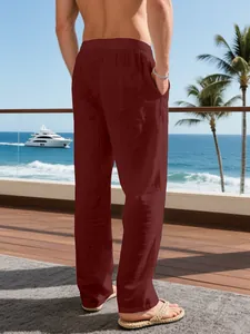 Back view of men's loose burgundy linen pants for summer vacation on a beach deck