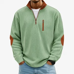 Macro view of green corduroy half-zip sweatshirt featuring distinct brown elbow patches