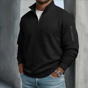 Détail d'un polo noir pour homme avec motif damier et poche zippée sur la manche