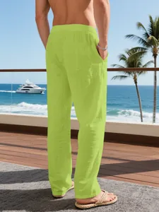 Rear view of bright lime green linen trousers for men in a relaxing beach resort scene