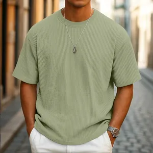 Close-up view of a men's sage green waffle knit short sleeve T-shirt with premium texture.