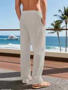 Back view of loose men's linen holiday trousers in light grey on a sunny balcony