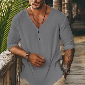 Gros plan d'une chemise grise à manches longues et col en V sur fond de plage
