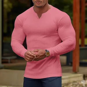 Detail view of men's pink ribbed long sleeve T-shirt showing texture and muscular fit