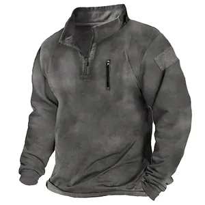 Détail d'un sweat tactique gris avec col montant, poche poitrine et patch velcro sur le bras.
