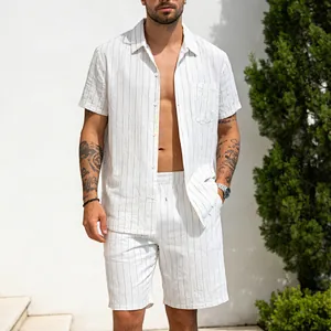 A male model wearing a white striped linen shirt and shorts set in a summer outdoor setting