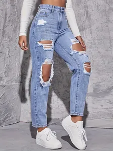 Detailed view of light blue ripped straight-leg jeans on a model with white sneakers